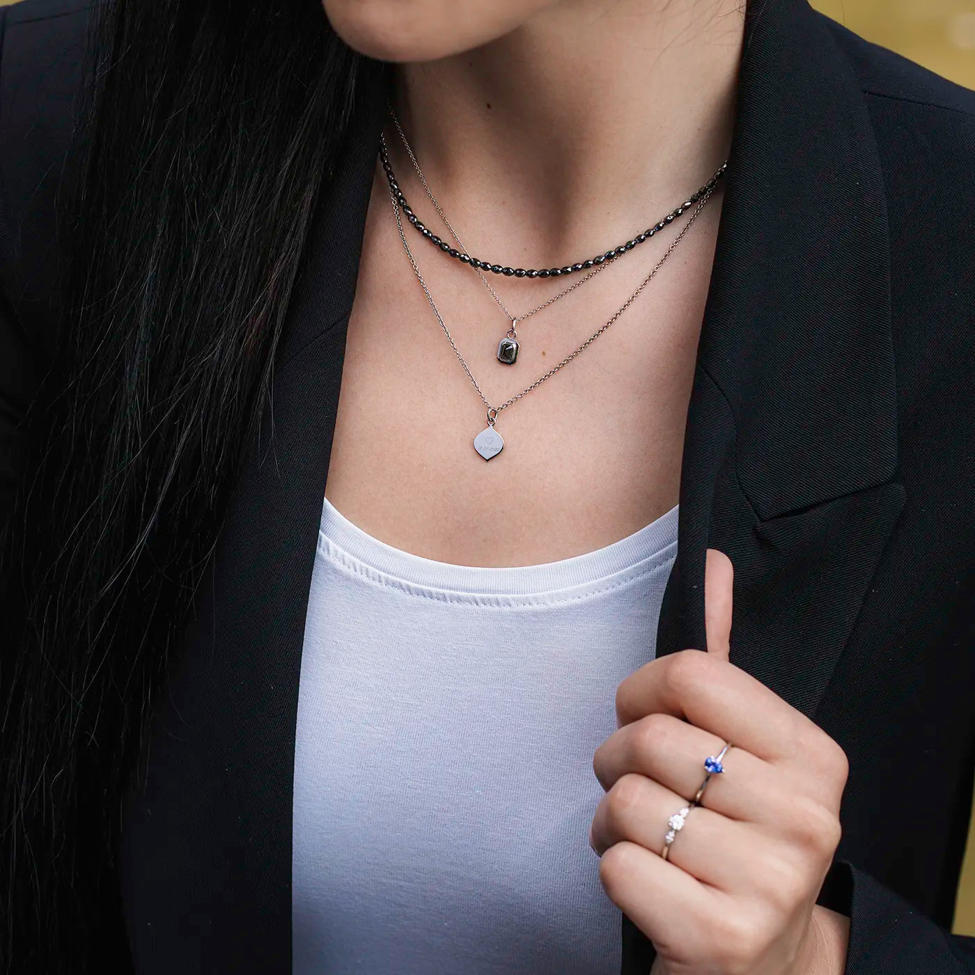 Anhaenger mit Ankerkette schwarzer Diamant 0.45ct Achteck in Platin an Modelhals bei Sonne nah mit schwarzer Diamantkette und Gravurplaettchen Josefine Platin von schraeg unten