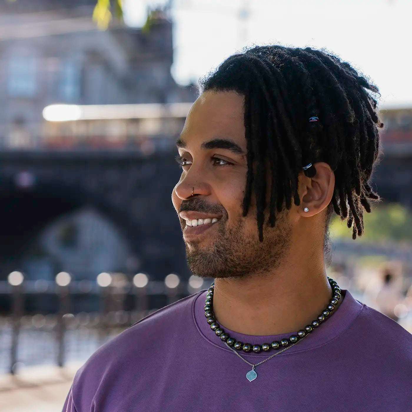 Gravurplaettchen aus Platin in Josefine Logoform in der Grösse 13x21mm
an maennlichem Modelhals total Model laechelt