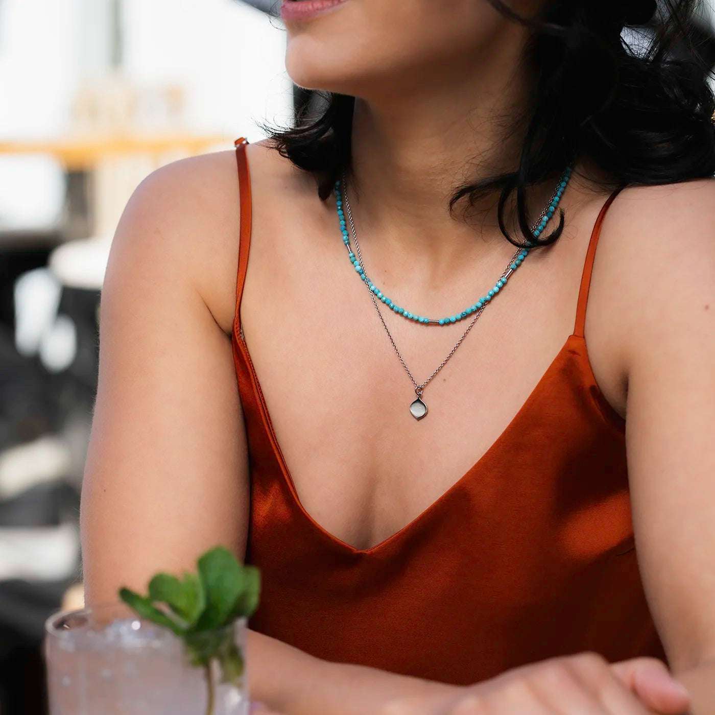 Gravurplaettchen aus Platin in Josefine Logoform in der Grösse 10x15mm
an modelhals nah mit rotem Oberteil