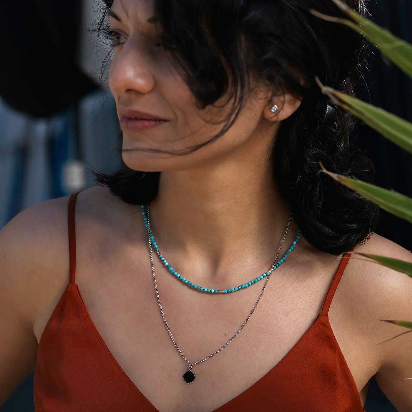 Gravurplaettchen aus Platin in Josefine Logoform in der Grösse 10x15mm
an modelhals halbnah mit rotem Oberteil