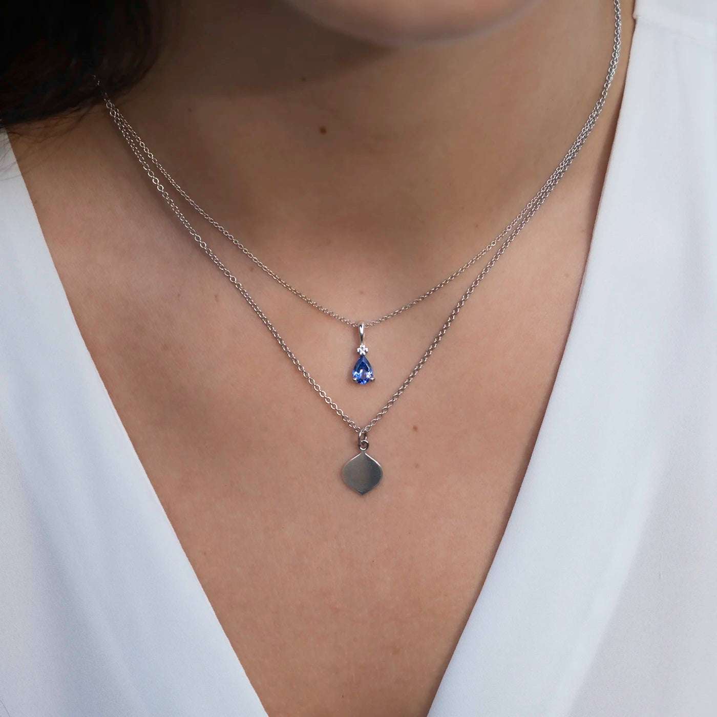 Anhaenger Blossom an Kette blauer Tansanit Tropfen Platin an modelhals mit Gravurkette Josefine in Platin nah