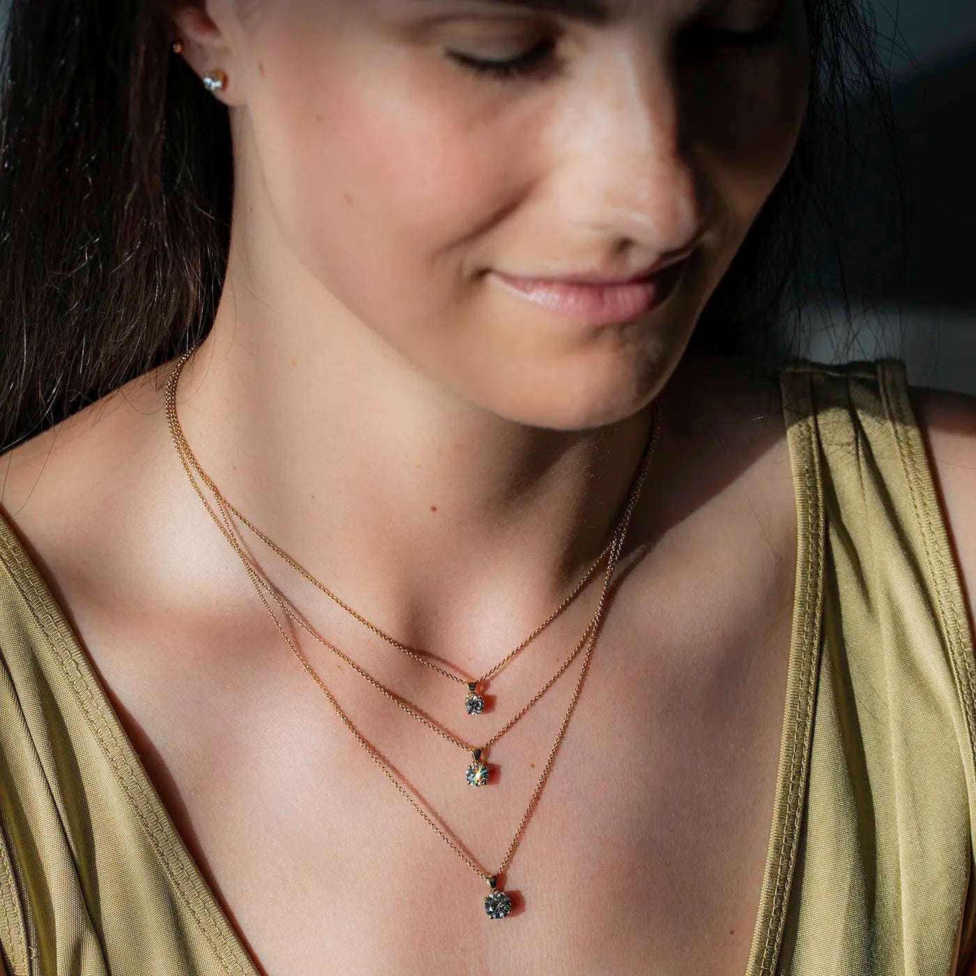 Anhaenger Petite Fleur Layering mit 0.50ct 0.80ct und 1.20ct Brillanten in Gelbgold an modelhals Closeup in Sonnenlicht