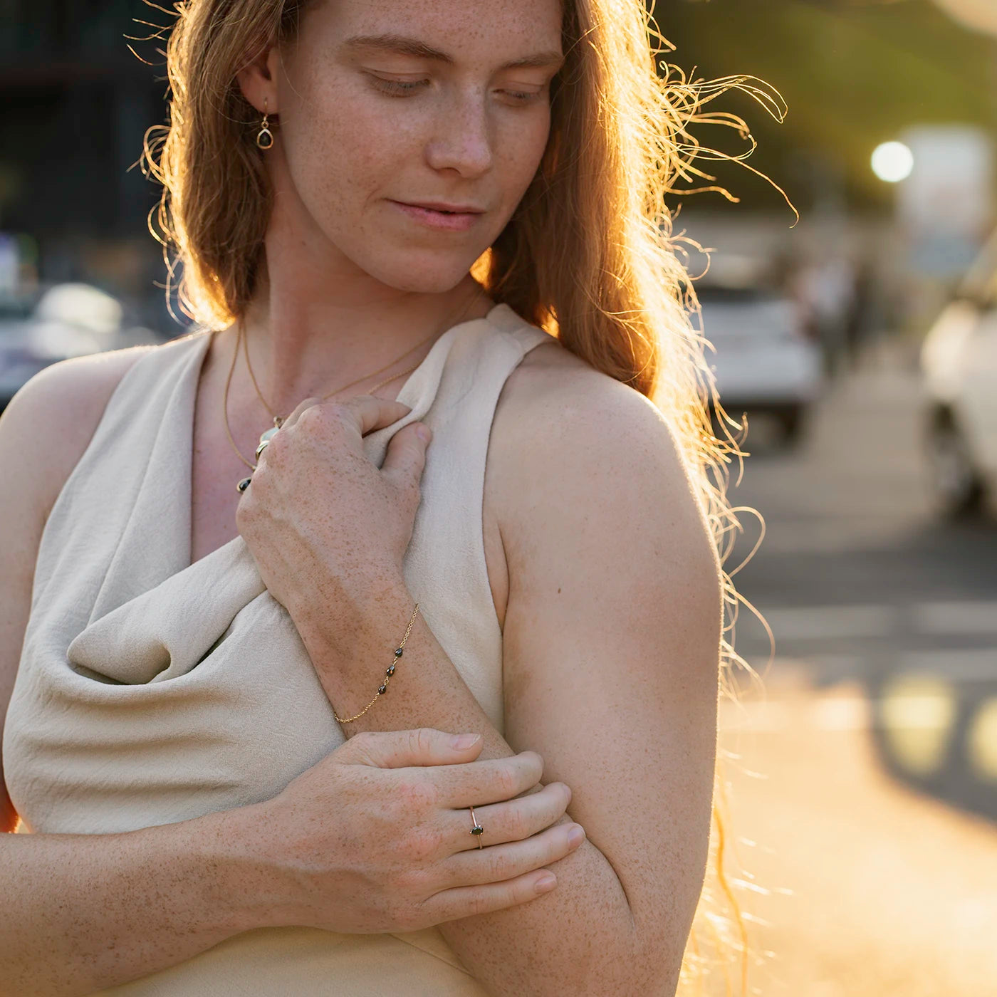 Armband aus Gelbgold mit drei schwarzen Diamanten Tropfenform an Modelarm Sonnenuntergangs Sonne auf Haar