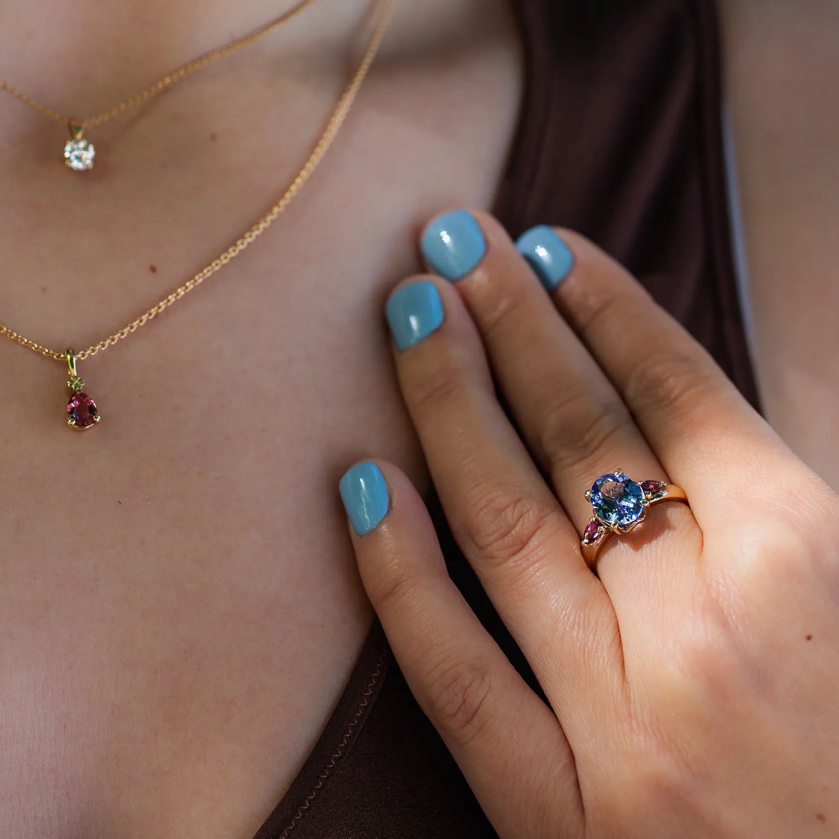 Blumenring mit blauem Tansanit an weiblicher Modelhand close up