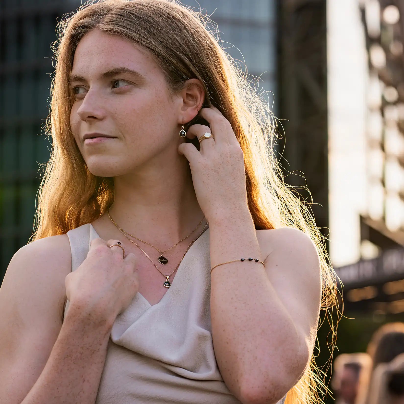 weibliches Model mit schwarzem Diamantohrhaenger im Abendlicht