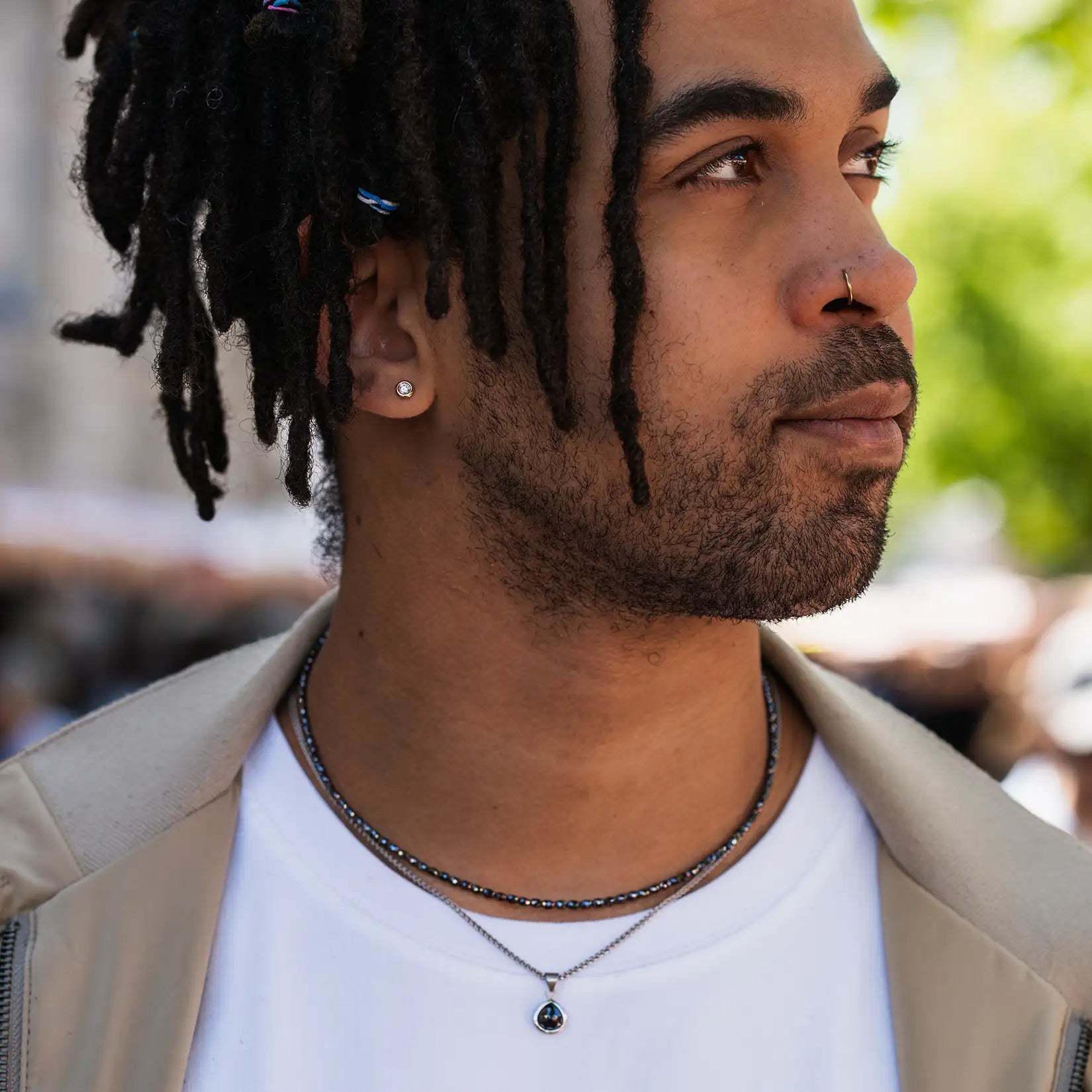 Maennliches Model traegt schwarze Diamantkette und Diamantanhänger in Platin