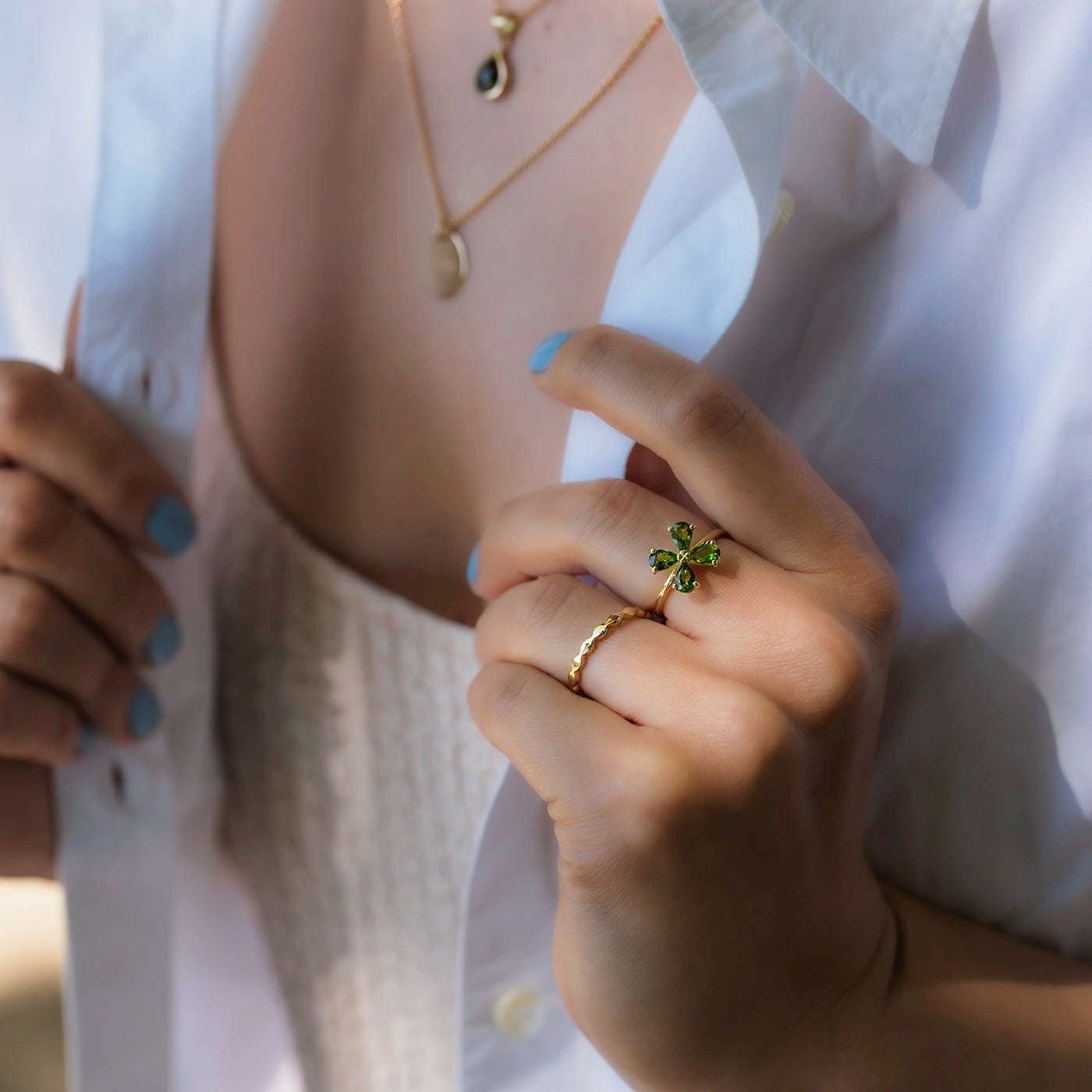 Ring Wave Gelbgold die Ringschiene ist geschwungen wie Wellen Frontansicht an Modelhand an Ringfinger weiterer Winkel MIttelfinger Blossom Forever gruener Turmalin