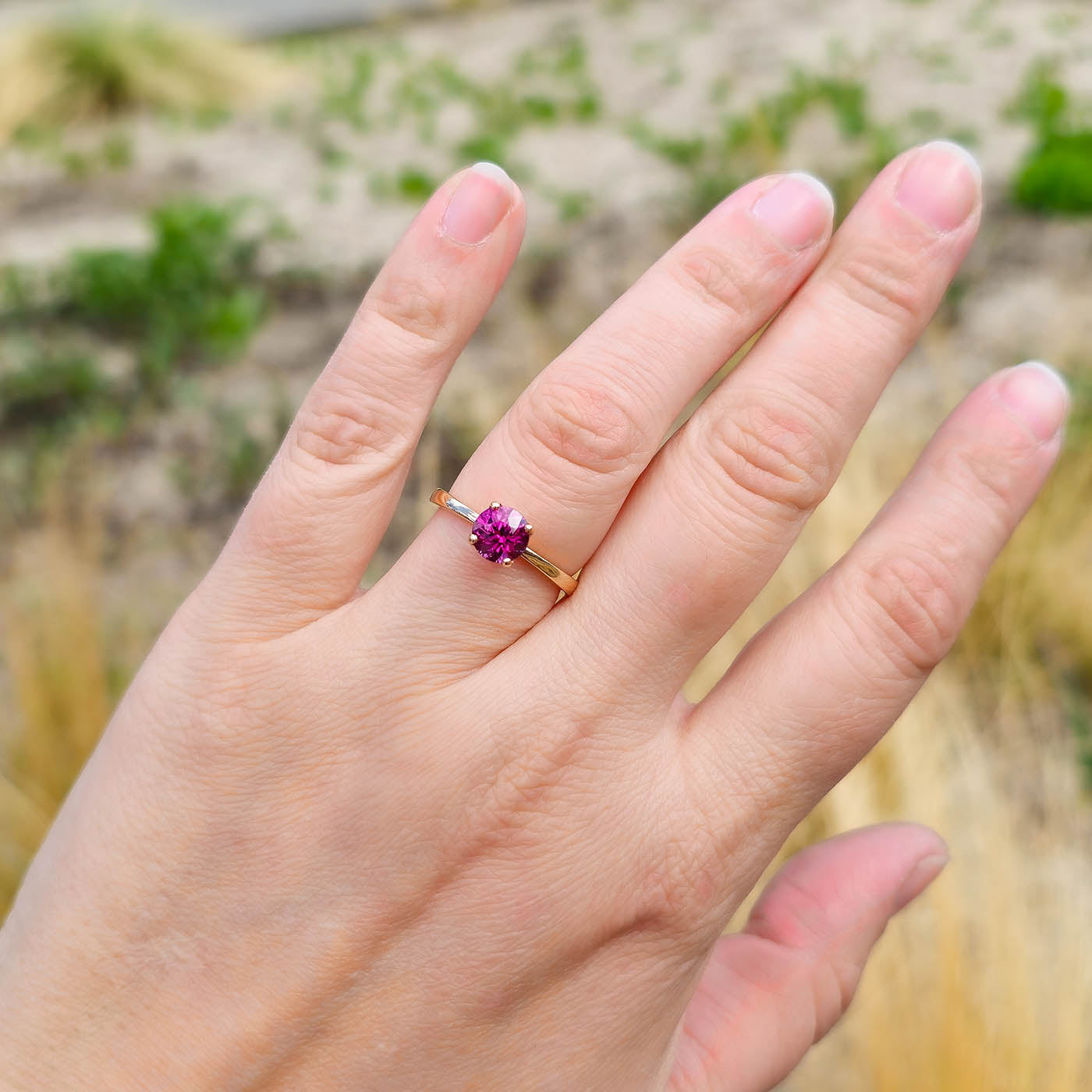 Ring Fleur Solitär Roségold mit rotem Granat getragen an Ringfinger