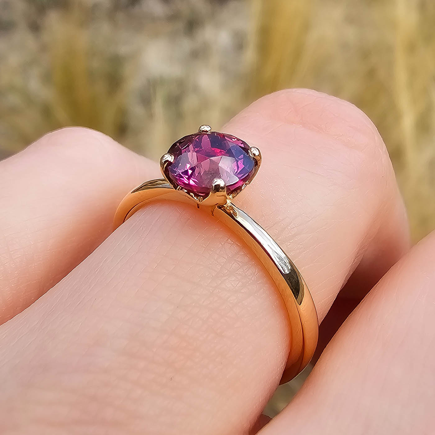 Ring Fleur Solitär Roségold mit rotem Granat getragen an Ringfinger closeup