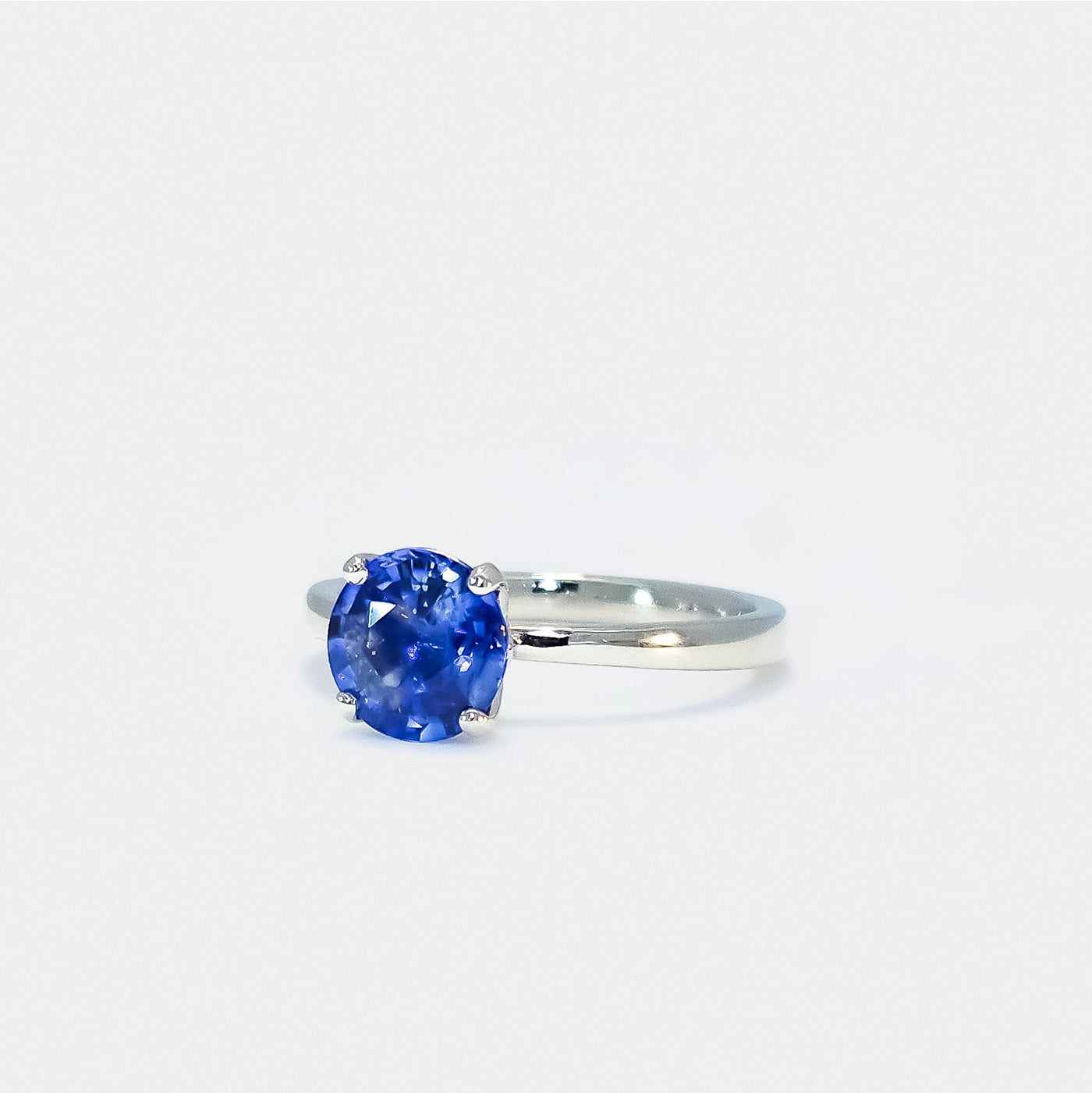 Ring Fleur Solitär aus 950er Platin in Front Ansicht mit blauem Saphir 25Grad nach links gedreht