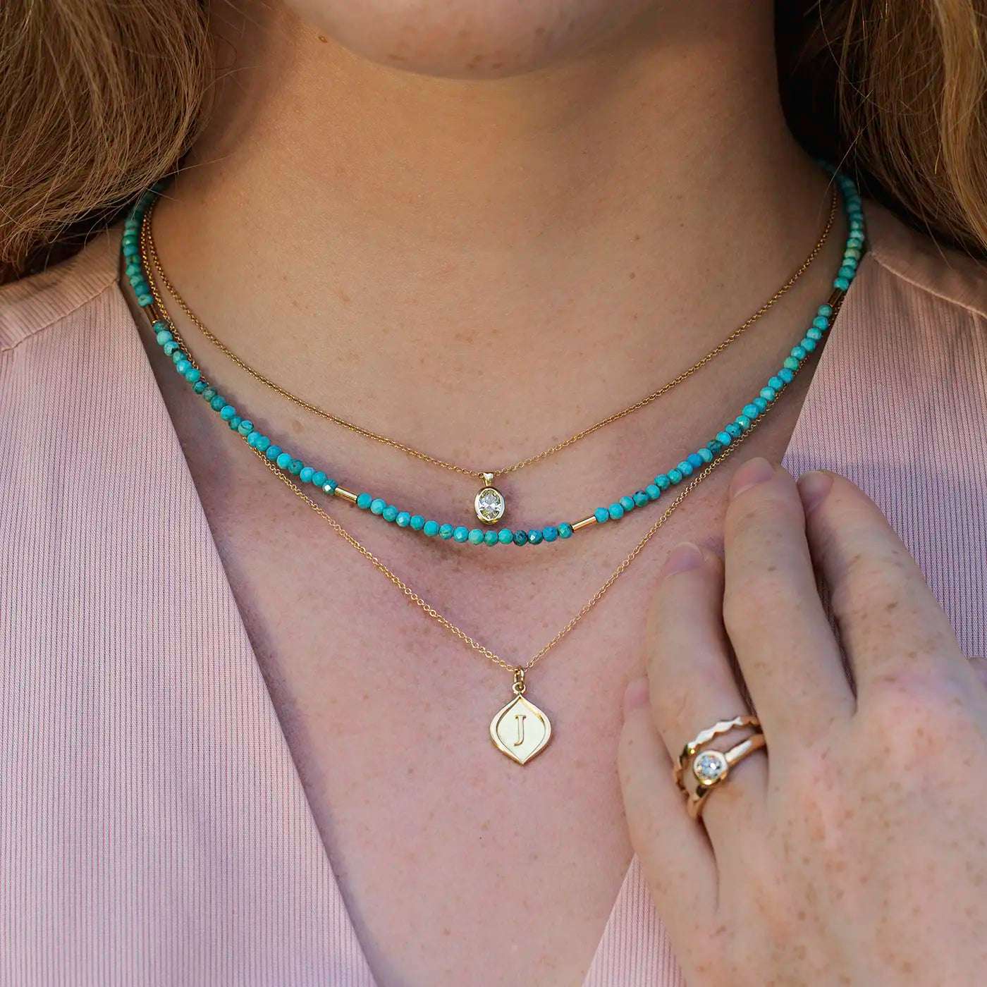 Gravurplaettchen mit 3D Initialen Gelbgold hier ein J an Modelhals frontal nah mit Edelsteinkette Lapis