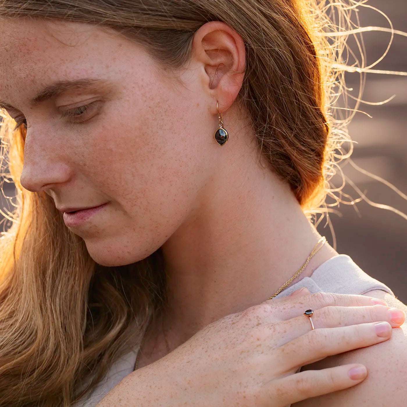 Ohrhaenger schwarzer Diamant Navette 2.0ct an Modelohr nah Sonnenuntergangslicht im Nacken