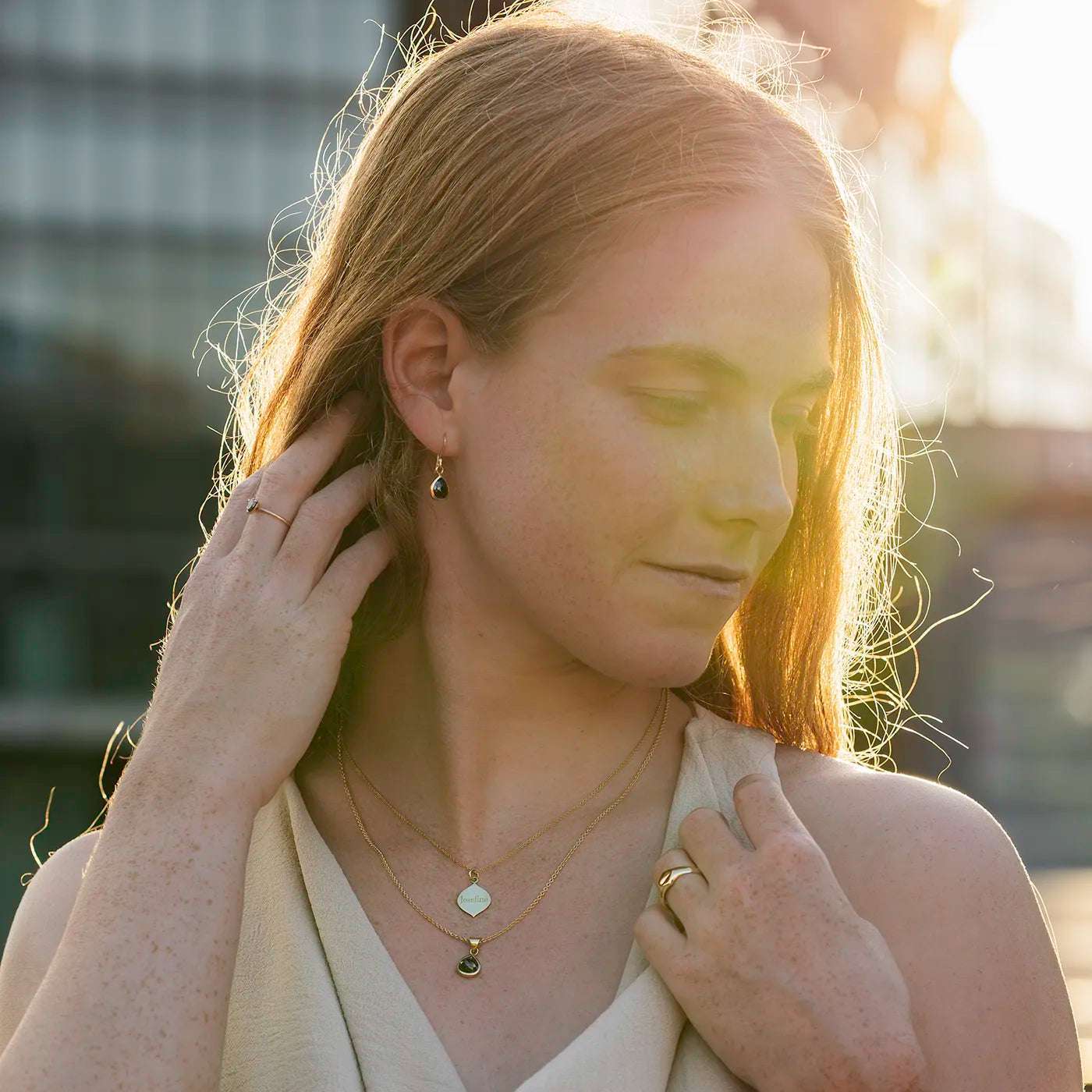 Ohrhaenger schwarzer Diamant Tropfenformi 1.2ct Gelbgold Profil an Modelohr halb nah Sonnenuntergangslicht auf Haar Model mehr eingedreht