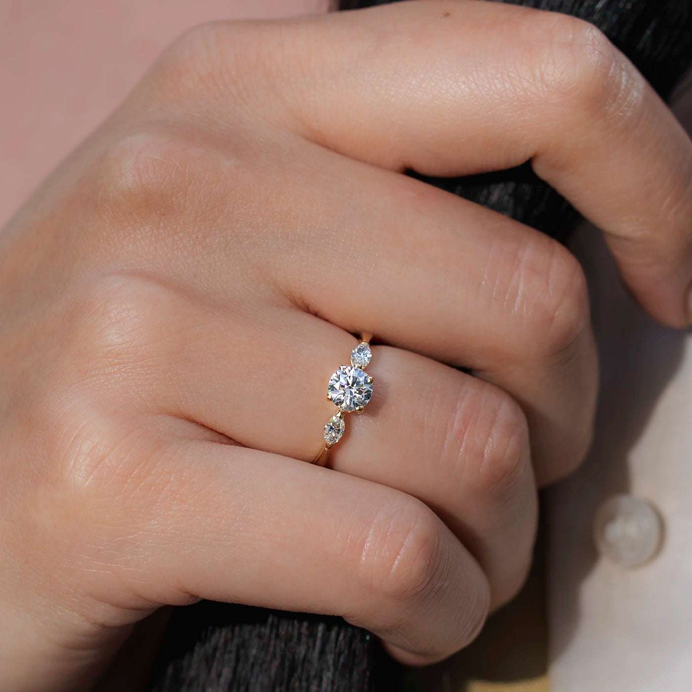 Ring Petite Fleur Mittelstein 0.75ct Brillant von 2 Navette Diamanten flankiert Gelbgold in floralem Design an Modelhand Ringfinger sehr close