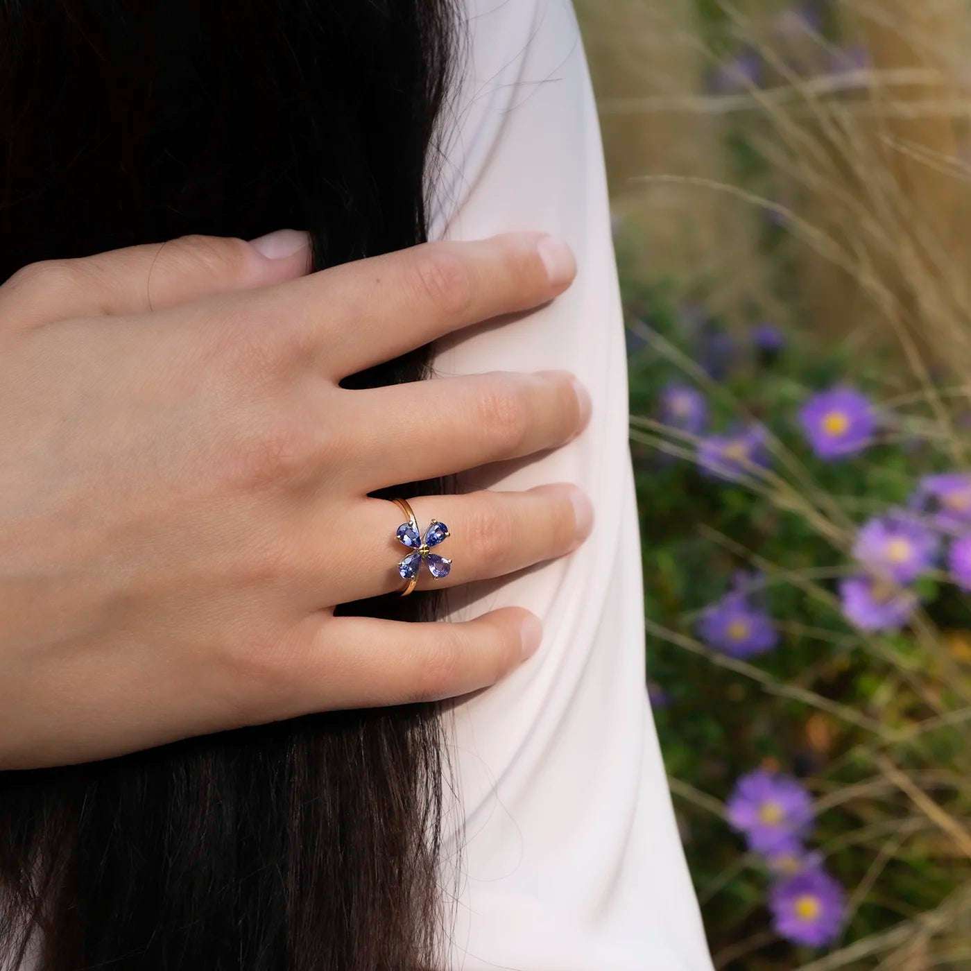 Ring 750er Gelbgold vier blaue Tansanite florales Design Modelhand vor Arm
