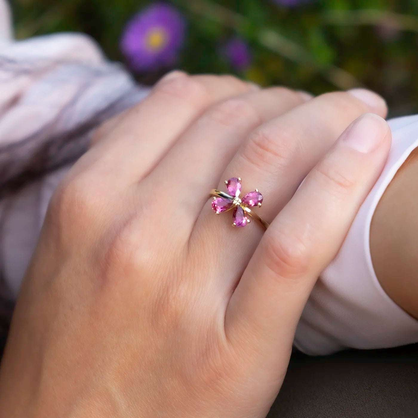 Ring 750er Gelbgold vier rosa Turmaline florales Design Front Modelhand auf Knie Closeup