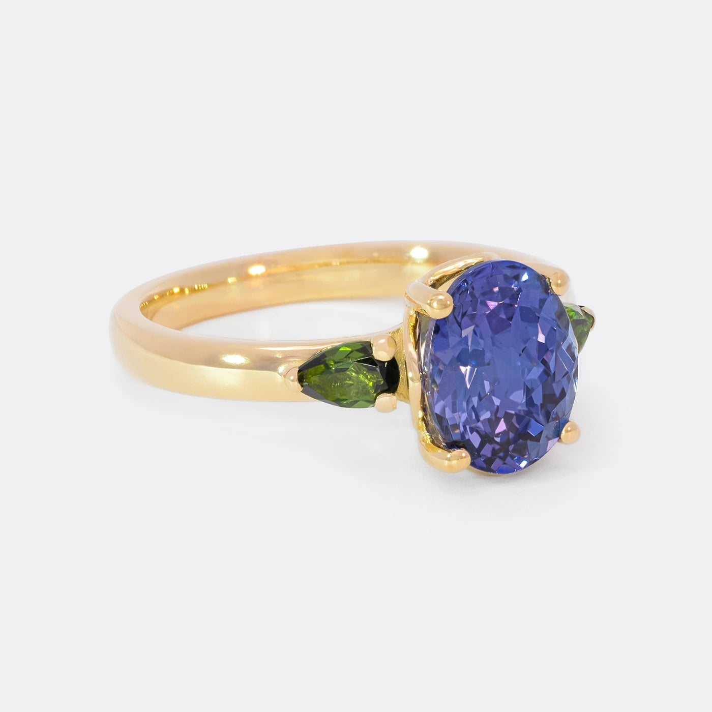 Ring Fleur Unikat blauer Tansanit und zwei gruene Turmaline Gelbgold im floralem Design Frontansicht 45Grad rechts gedreht