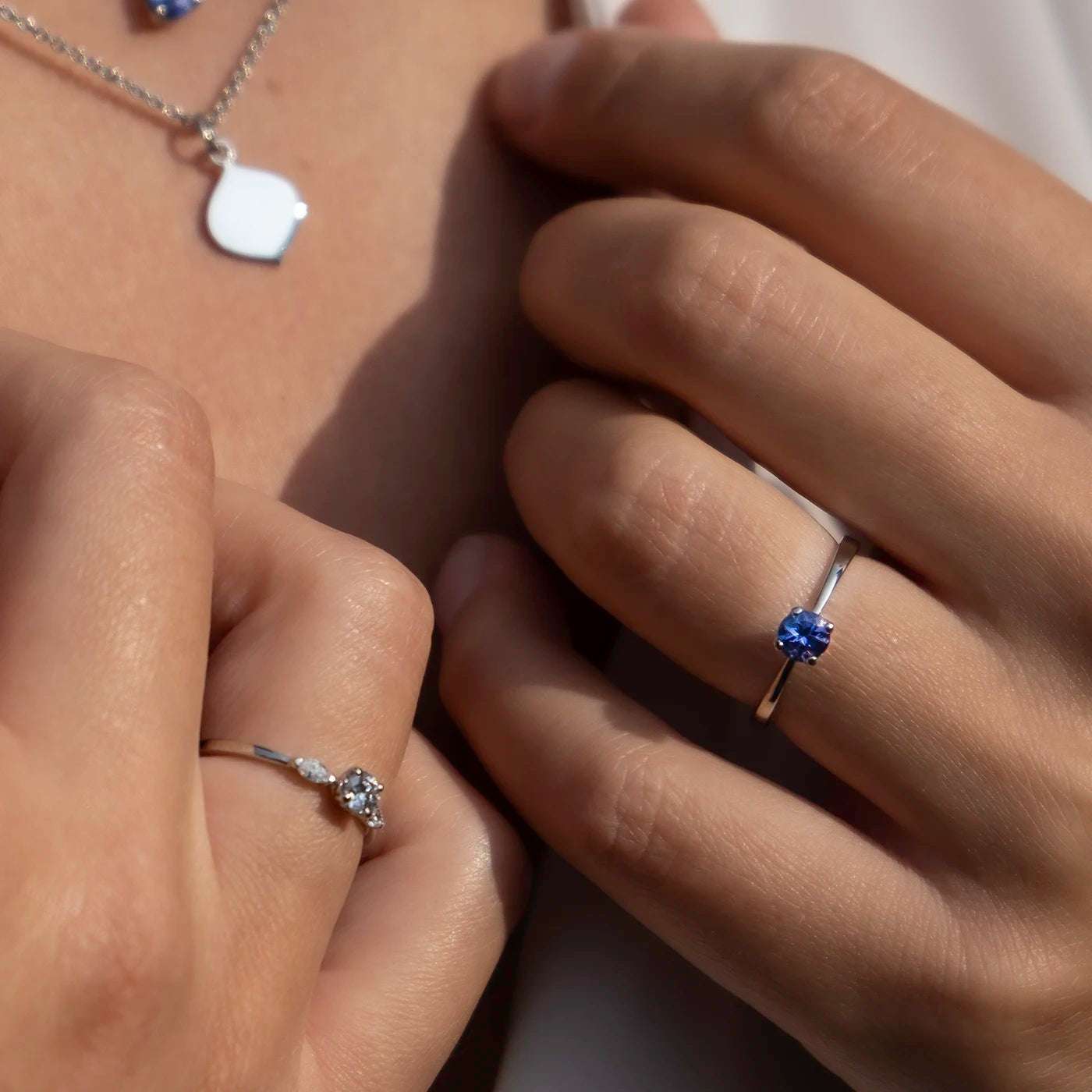 Ring Mermaid 950er Platin ein blauer Tansanit an Modelhand am Kragen closeup