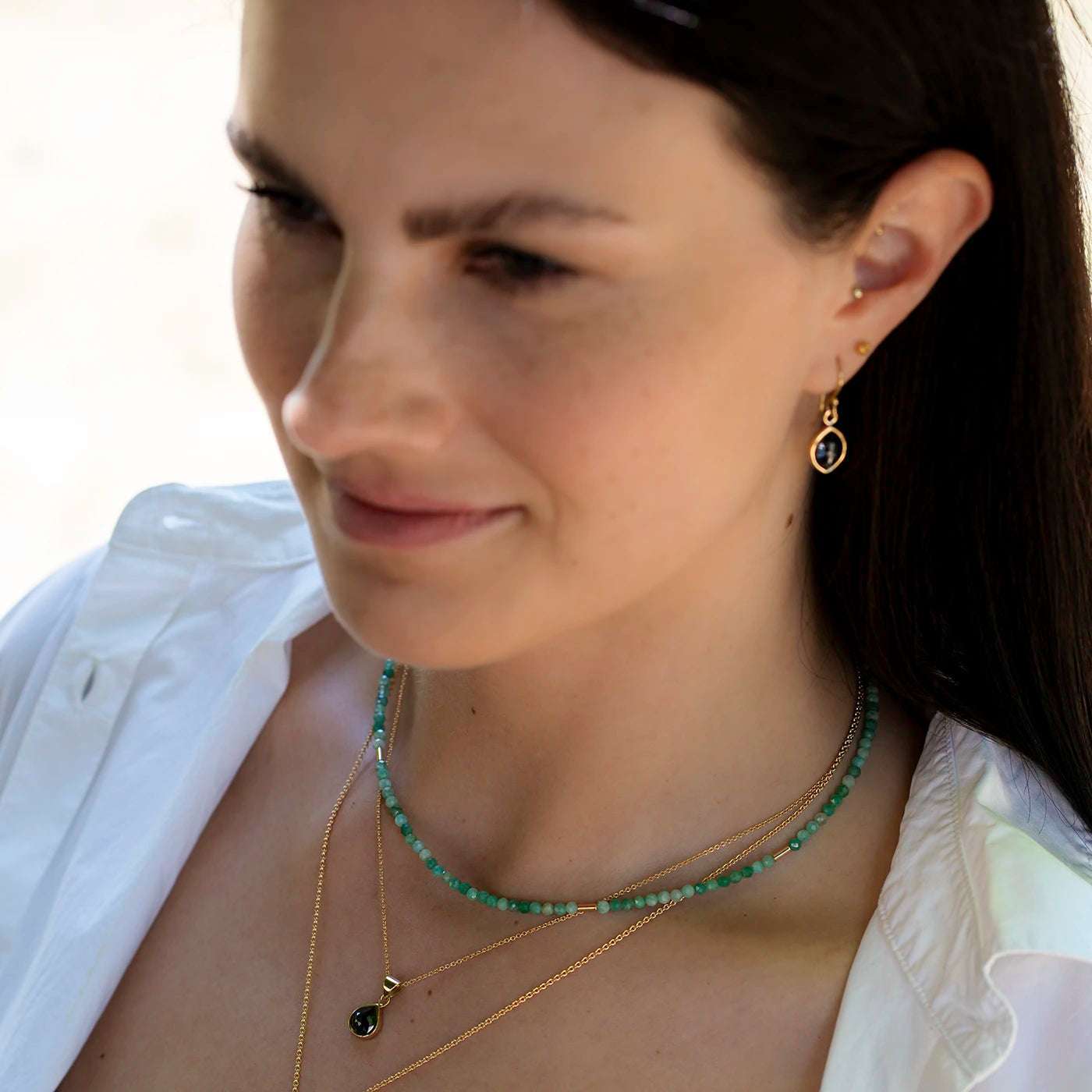 Edelsteinkette Smaragd mit Gelbgold Elementen an Modelhals halbnah
