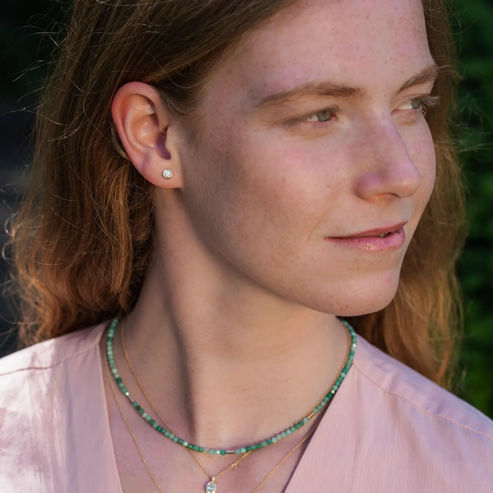 Unisex Ohrstecker Balance Gelbgold an Ohr rothaariger Frau die nach rechts schaut