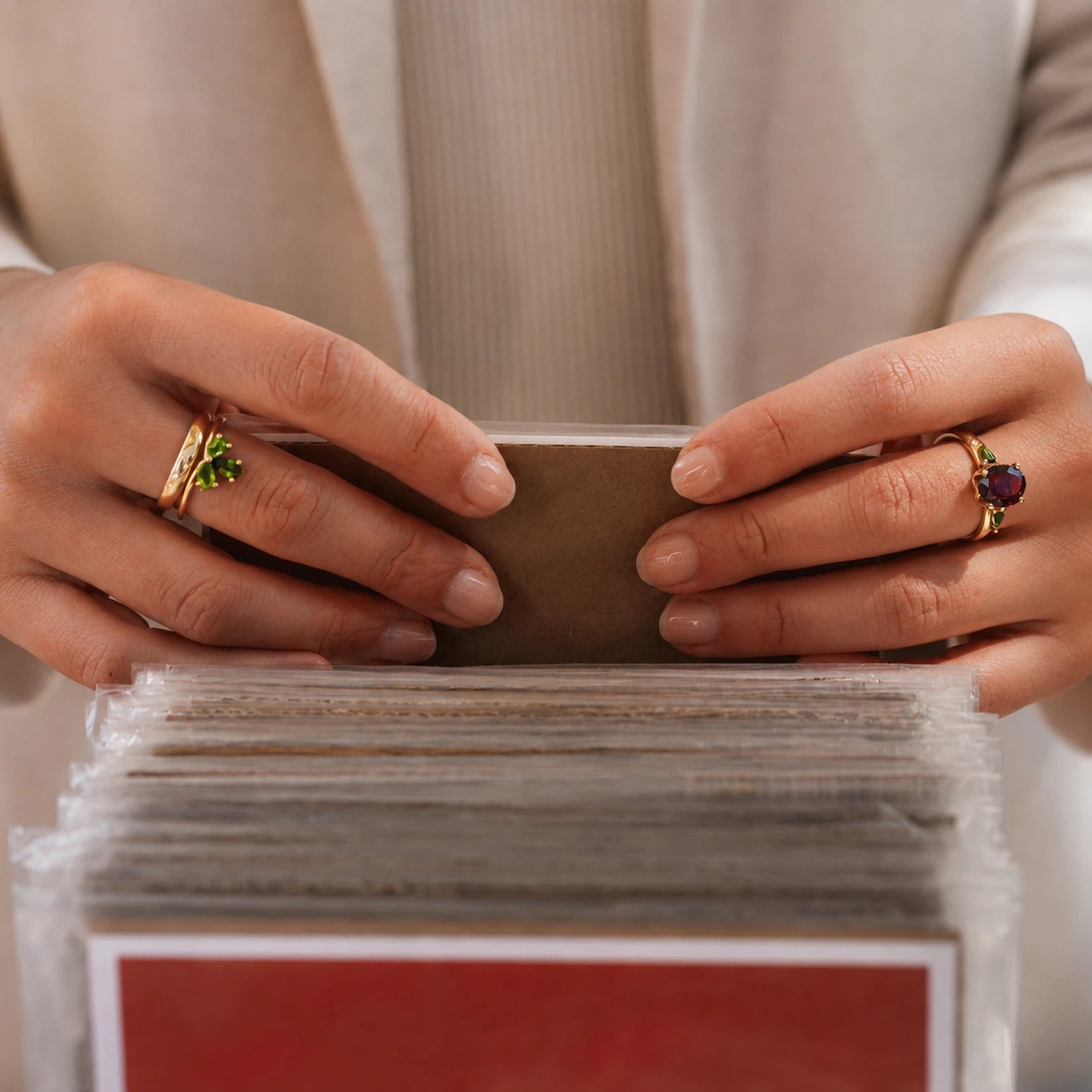Alt-Text für Block 2:
„Zwei Edelsteinringe an den Händen, links ein Ring mit grünen Steinen, rechts ein Ring mit rotem Zentralstein und grünen Seitensteinen, aus dem Berliner Atelier von Josefine Berlin.