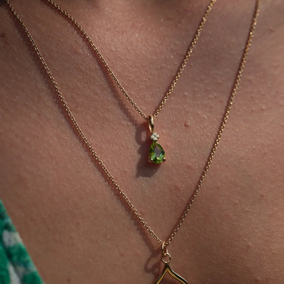 Kette mit Anhänger Blossom grüner Peridot aus 925er Sterlingsilber vergoldet - am Hals getragen, Nahaufnahme