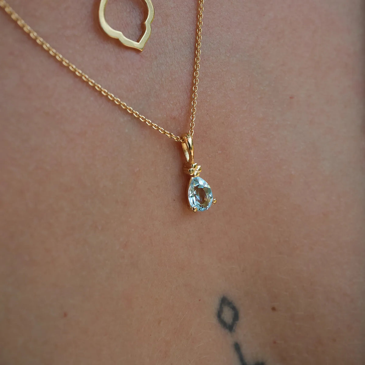 Kette mit Anhänger Blossom Kleeblatt hellblauer Topas aus 925er Sterlingsilber vergoldet - am Hals getragen, Nahaufnahme