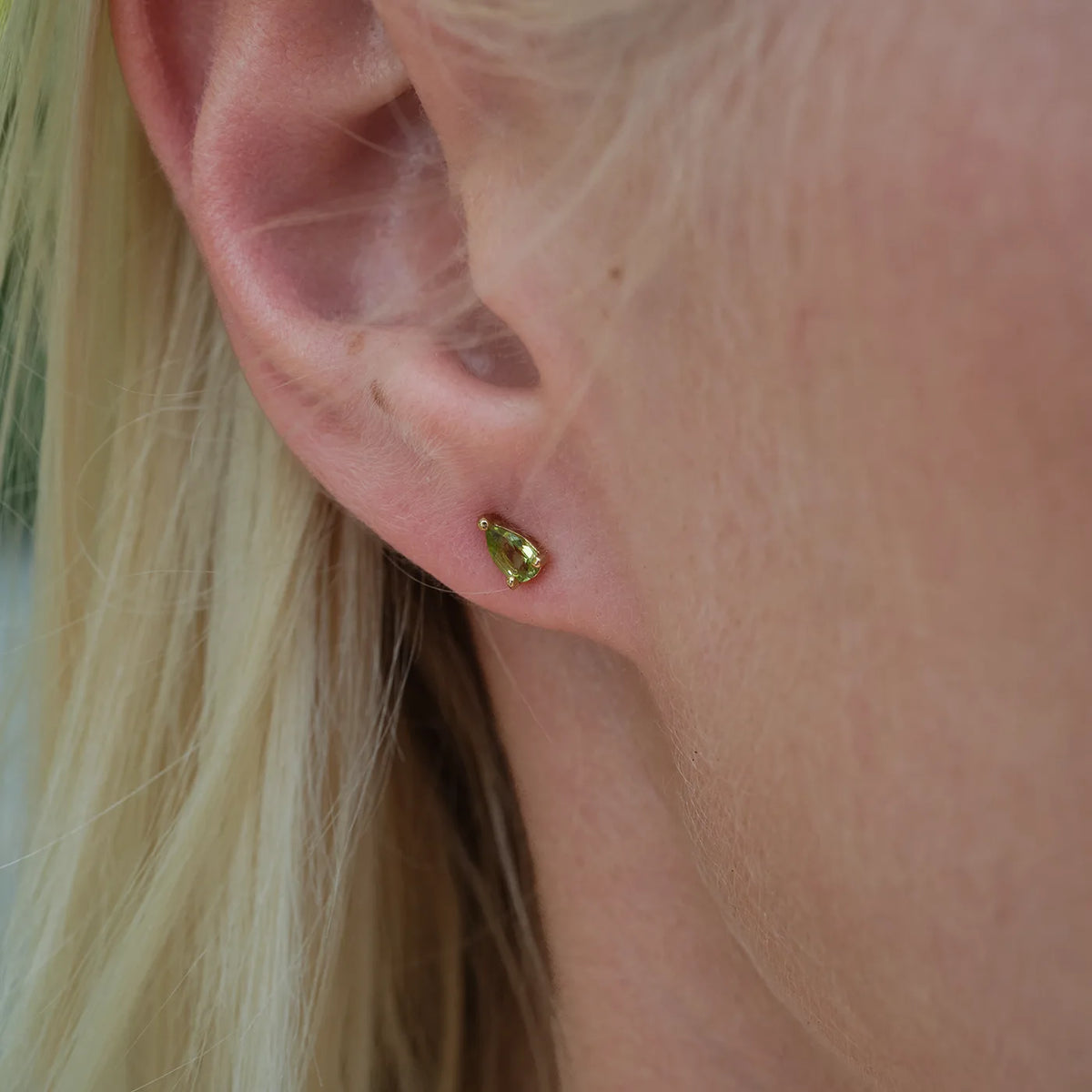 Ohrstecker Blossom grüner Peridot klein aus 925er Sterlingsilber vergoldet - am Ohr getragen, Detailansicht