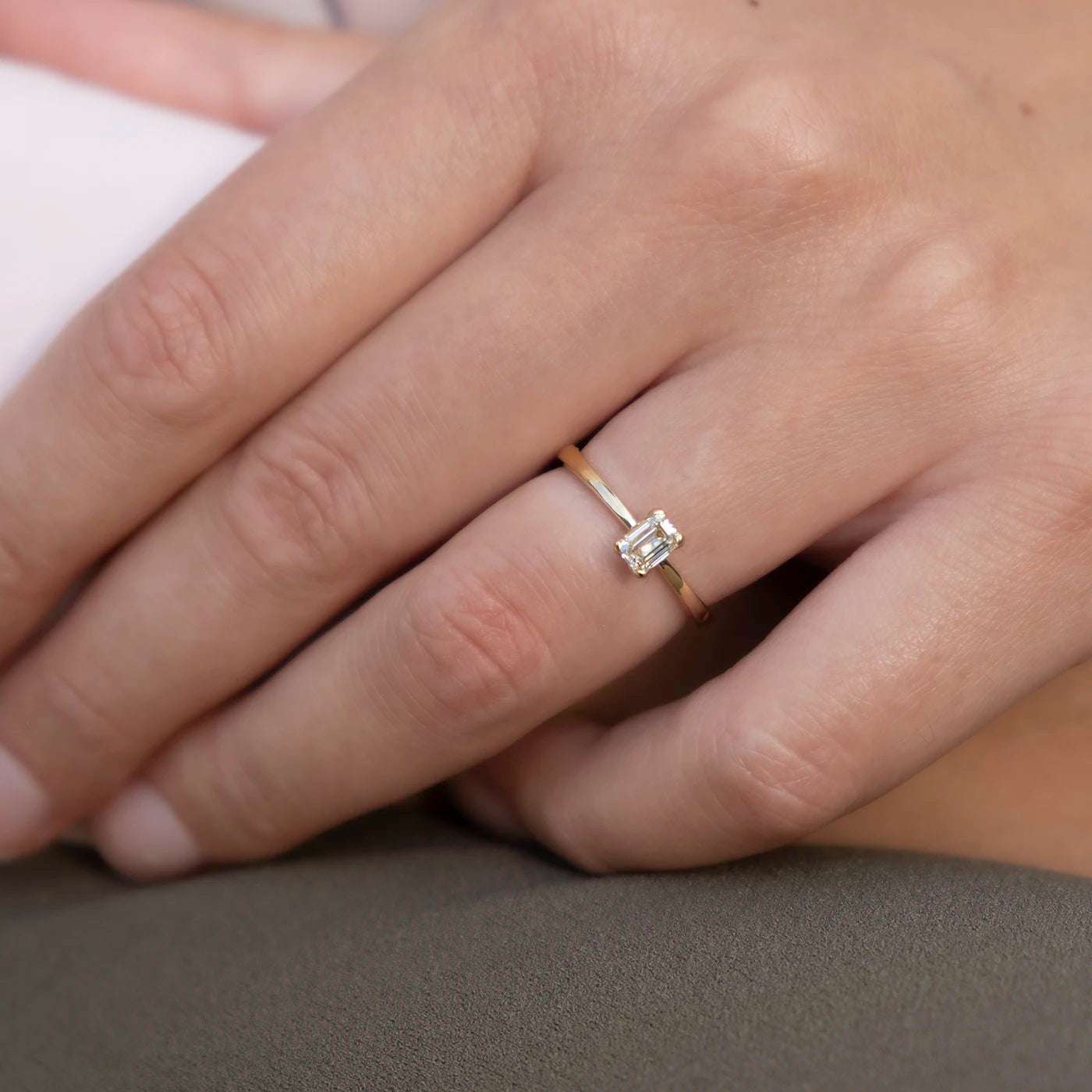 Ring Petite Fleur Solitär aus 750er Gelbgold mit Diamant im Smaragdschliff 0,50 ct an Modellhand im Detail
