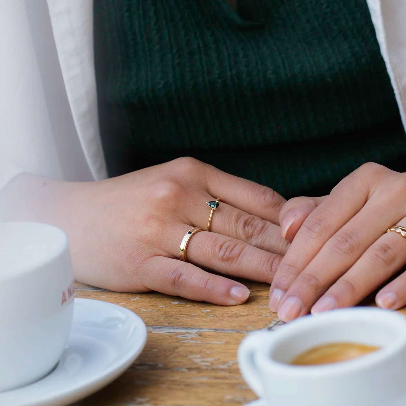 Ring Vintage Damenring Gelbgold Ringschiene mit kleinem Kugelmuster am Rand auf beiden Seiten an modelhand auf Ringfinger auf Kaffeetisch