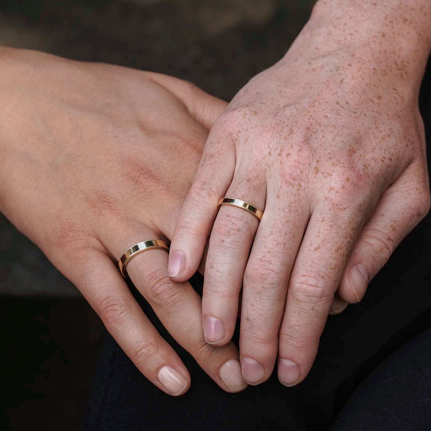 Ring Vintage Damenring und Herrenring Gelbgold Ringschiene mit kleinem Kugelmuster am Rand auf beiden Seiten an zwei modelhaenden auf jeweils Ringfinger Haende uebereinander gelegt