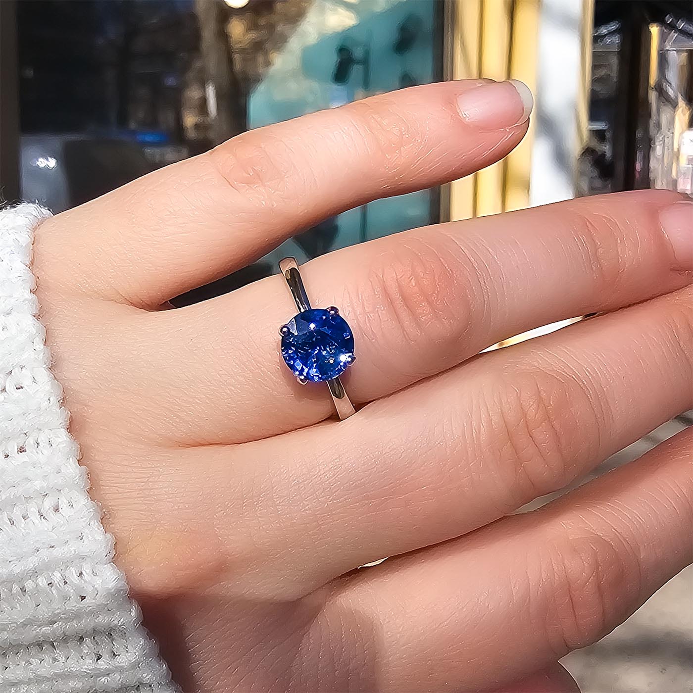Fleur Solitär blauer Saphir 950er Platin getragen an Hand in Sonnenlicht