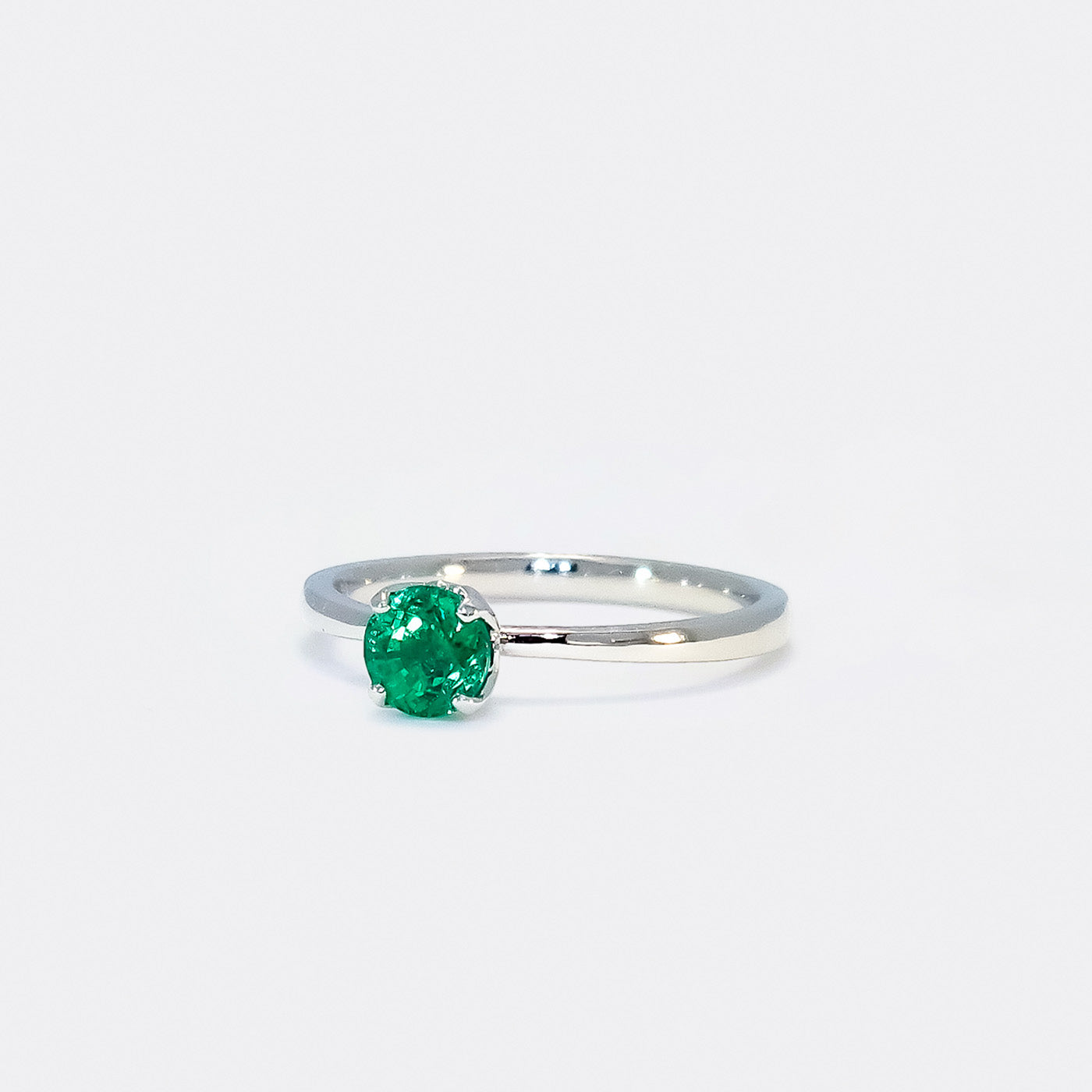 Ring Fleur Solitär aus 950er Platin in Front Ansicht mit gruenem Smaragd 25Grad links gedreht