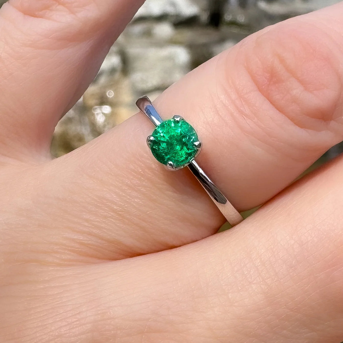 Petite Fleur Solitär Ring aus 950er Platin mit grünem Smaragd am Finger getragen closeup