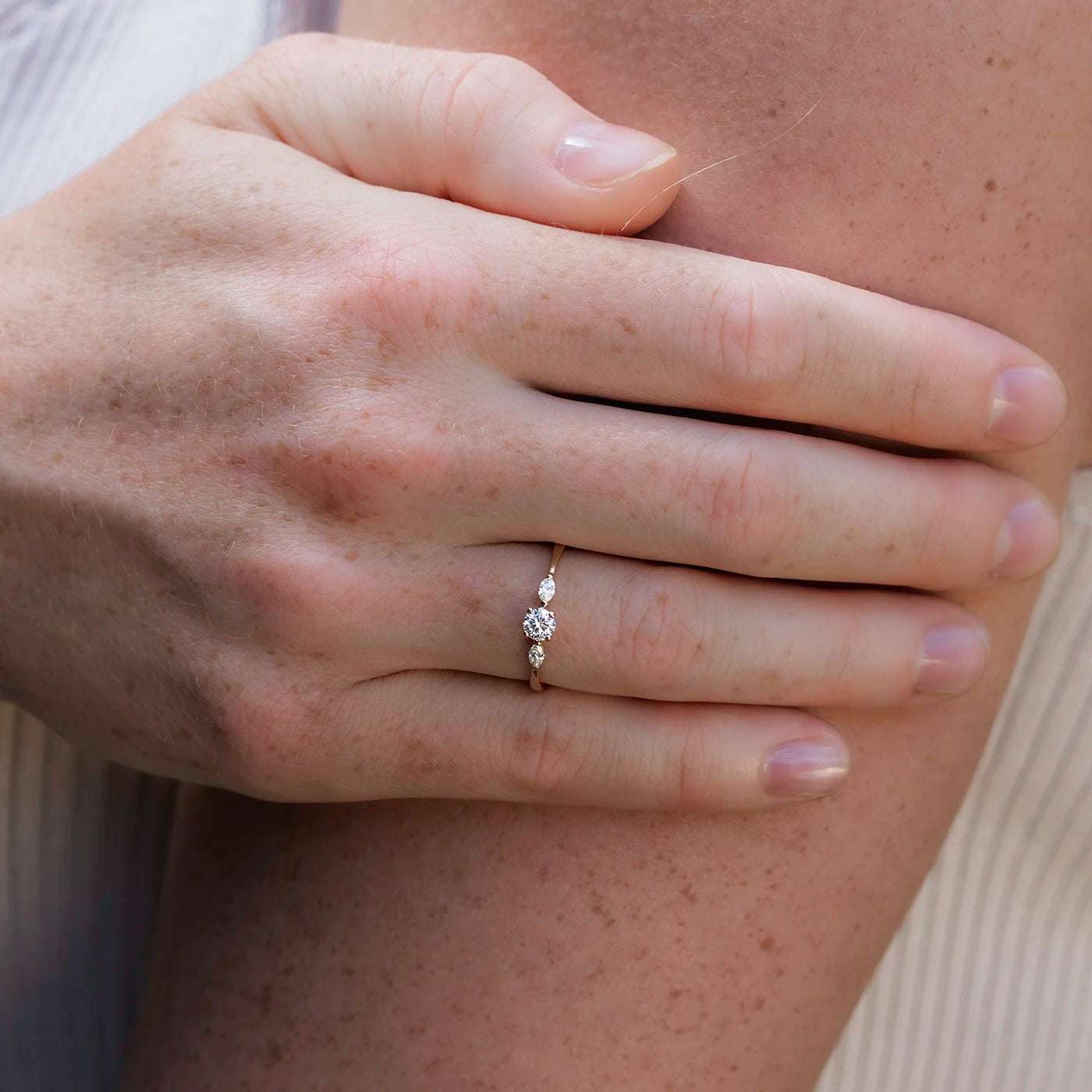 Ring Petite Fleur Mittelstein 0.25ct Brillant von 2 Navette Diamanten flankiert Rosegold in floralem Design Frontansicht an modelhand  an Oberarm angelegt closeup