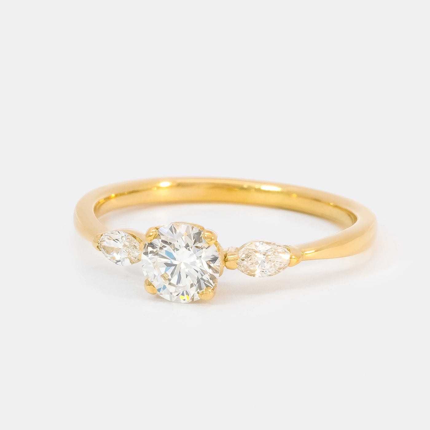 Ring Petite Fleur Mittelstein 0.50ct Brillant von 2 Navette Diamanten flankiert Gelbgold in floralem Design Frontansicht 25Grad links gedreht