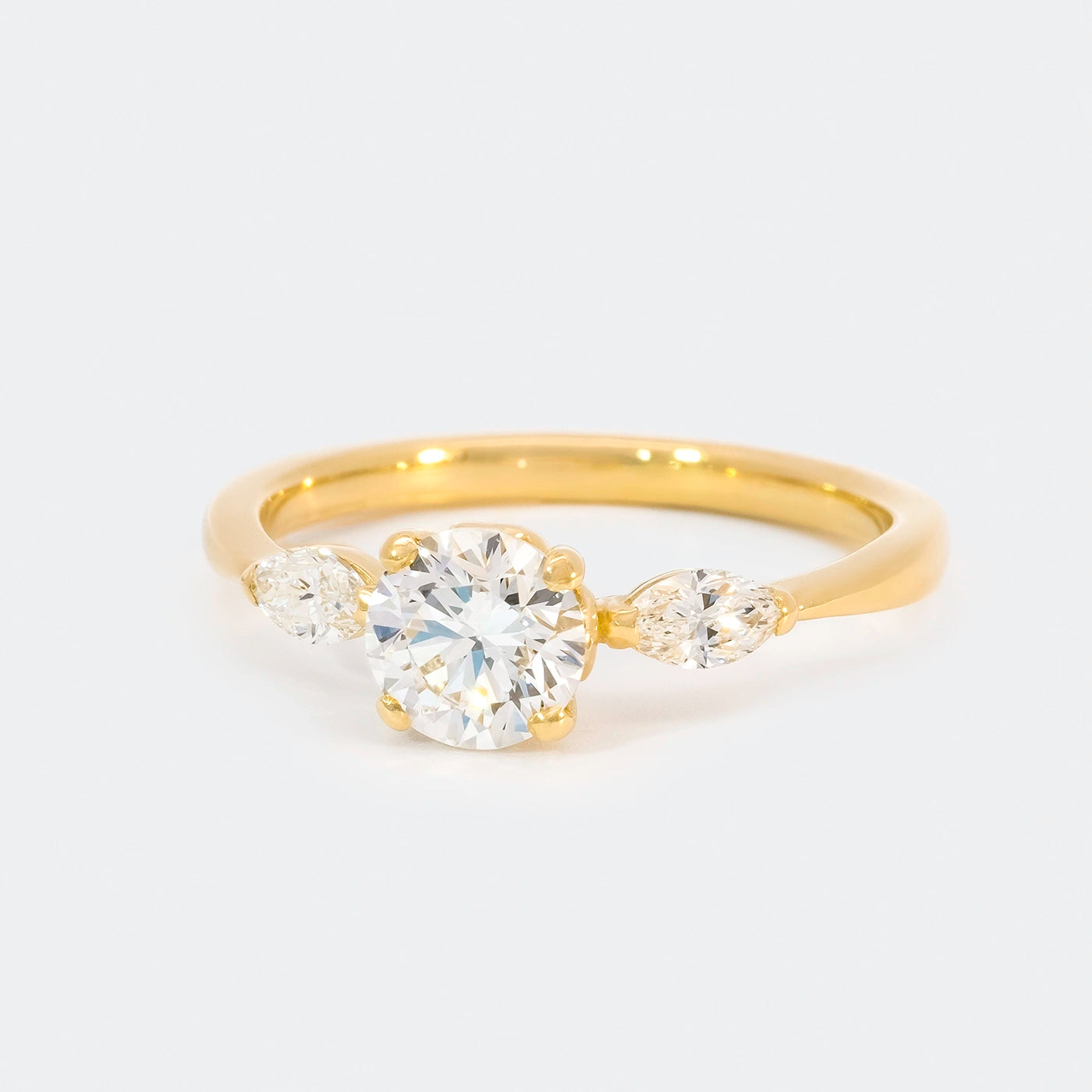 Ring Petite Fleur Mittelstein 0.75ct Brillant von 2 Navette Diamanten flankiert Gelbgold in floralem Design Frontansicht 25Grad links gedreht