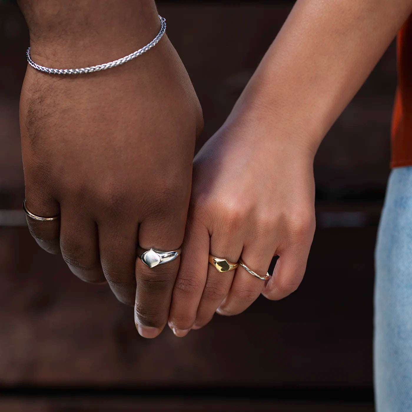 Siegelring Damen Gelbgold und Herrenring Platin mit grosser Flaeche in Form Josefine Logo fuer Wunschgravur Frontansicht an weiblich und maennlicher Modelhand Ringfingern halte Haende Closeup