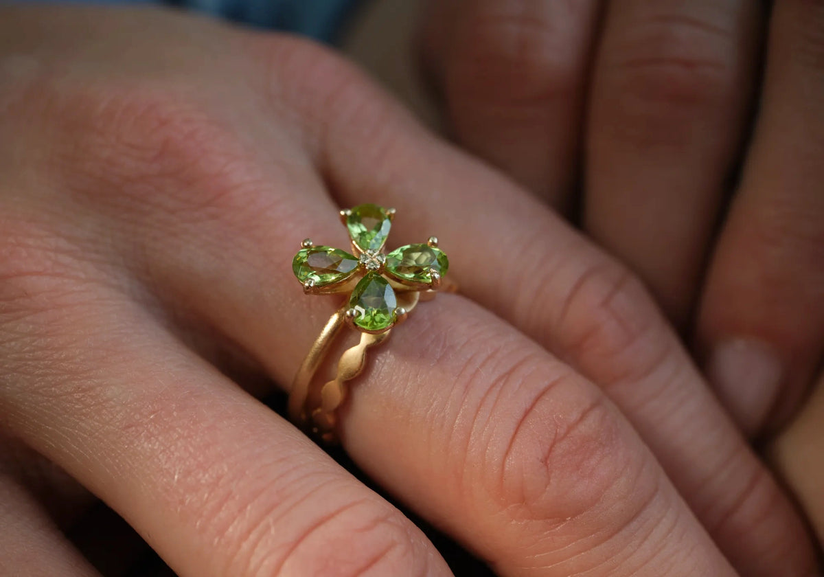 Ring Forever Blossom grüner Peridot und Ring Wave aus 925er Sterlingsilber vergoldet gestapelt an der Hand - Tragebild