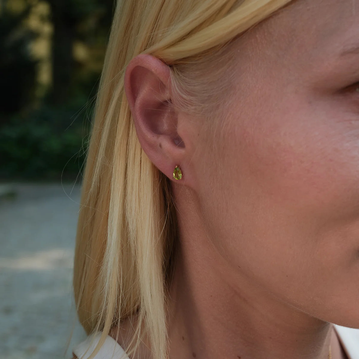 Ohrstecker Blossom grüner Peridot groß aus 925er Sterlingsilber vergoldet - am Ohr getragen, Porträt im Halbprofil