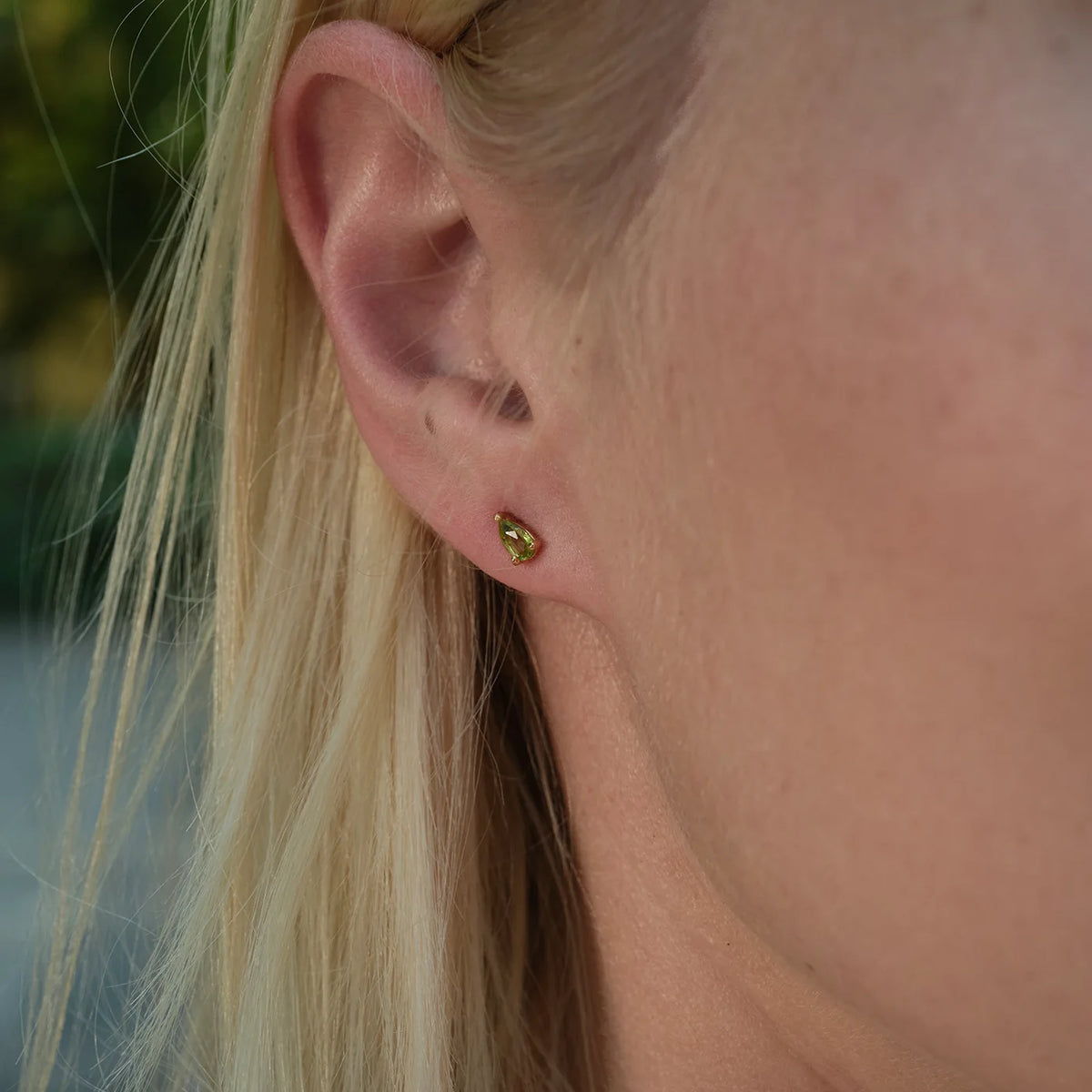 Ohrstecker Blossom grüner Peridot klein aus 925er Sterlingsilber vergoldet - am Ohr getragen, Nahaufnahme