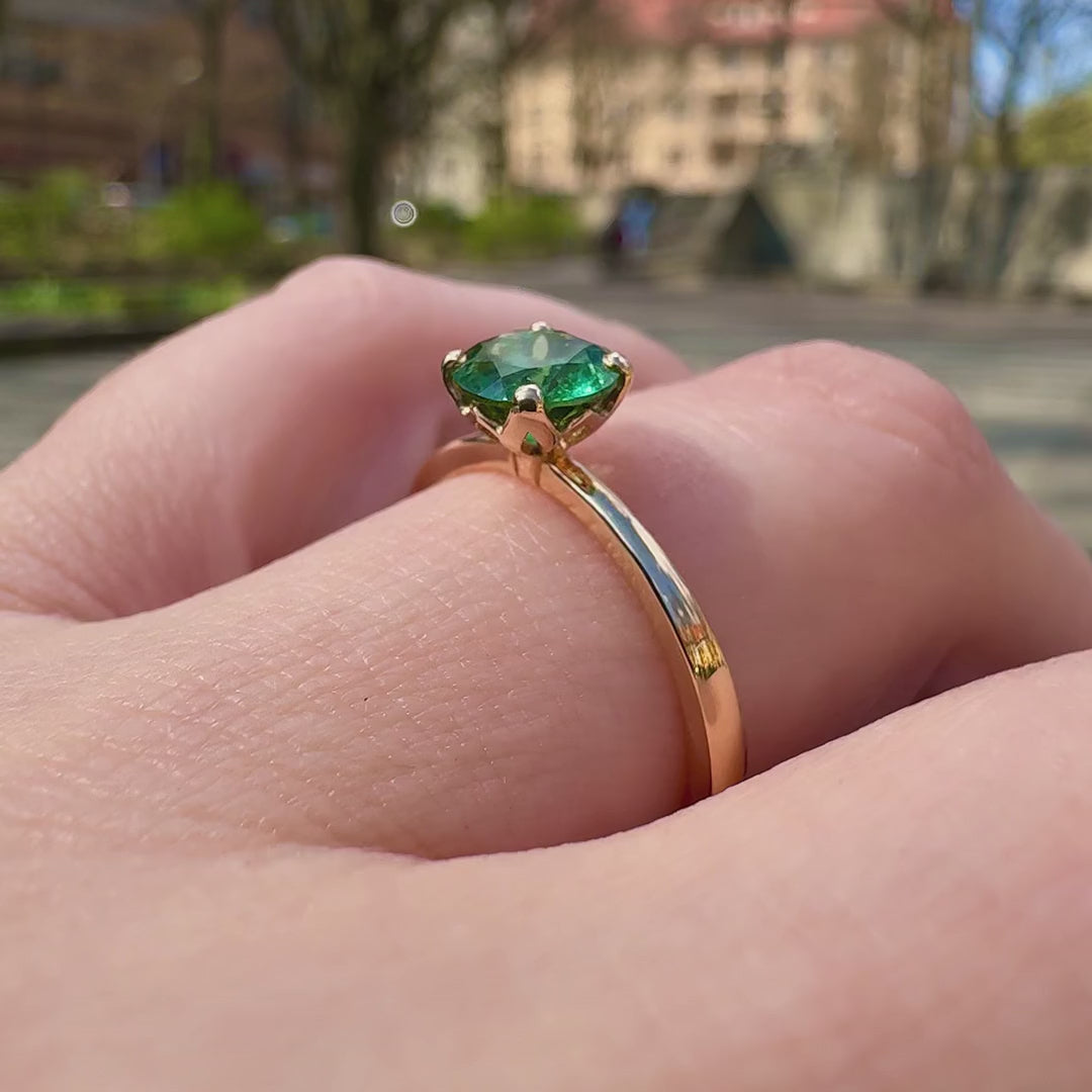 Ring Fleur Solitär Roségold getragen mit grünem Turmalin glitzert im Sonnenlicht nah zu total