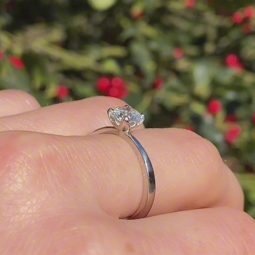 Petite Fleur Solitär Ring aus Platin mit 1 ct Diamant am Finger getragen in Drehbewegung mit farbigem Lichtreflex