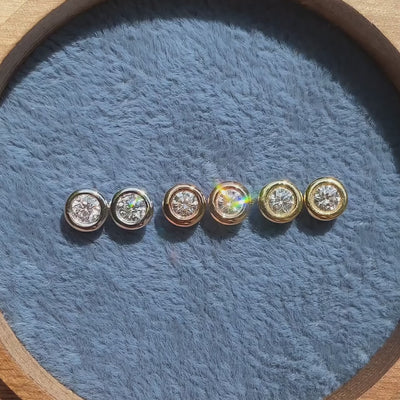 Ohrstecker Balance Platin Gelbgold Roségold zusammen im Schmuckkästchen mit Sonnenreflexionen