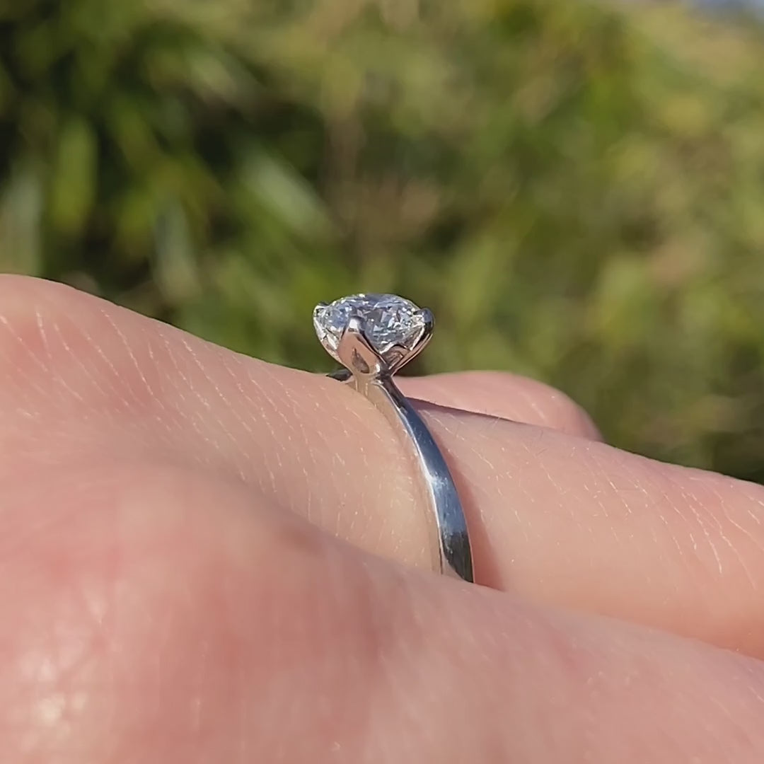 Petite Fleur Solitär Ring aus Platin mit 0,75 ct Diamant am Finger getragen in Drehbewegung im Sonnenlicht