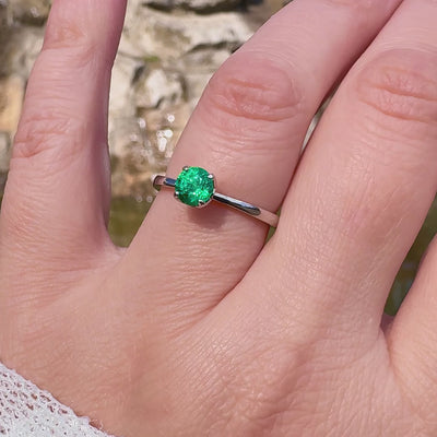 Petite Fleur Solitär Ring aus 950er Platin mit grünem Smaragd am Finger getragen in Drehbewegung
