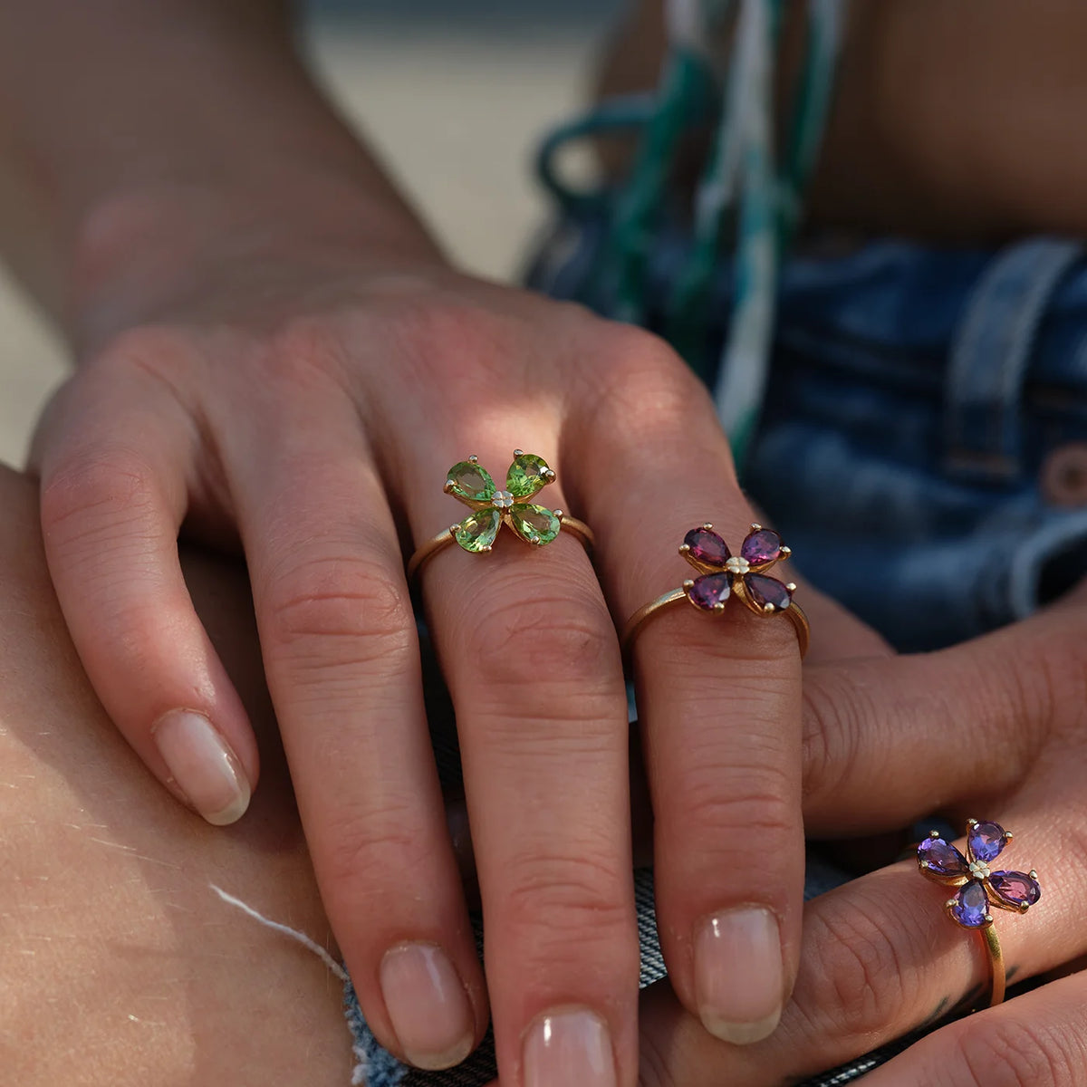 Ring Forever Blossom grüner Peridot, roter Granat und violetter Amethyst aus 925er Sterlingsilber vergoldet - am Finger getragen, Schrägansicht
