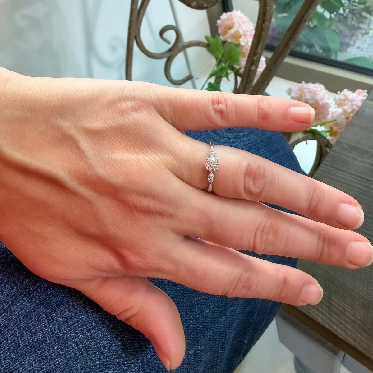 Ring Petite Fleur 0,50 ct aus 950er Platin mit Brillant und zwei Navetten - am Finger getragen, ganze Hand