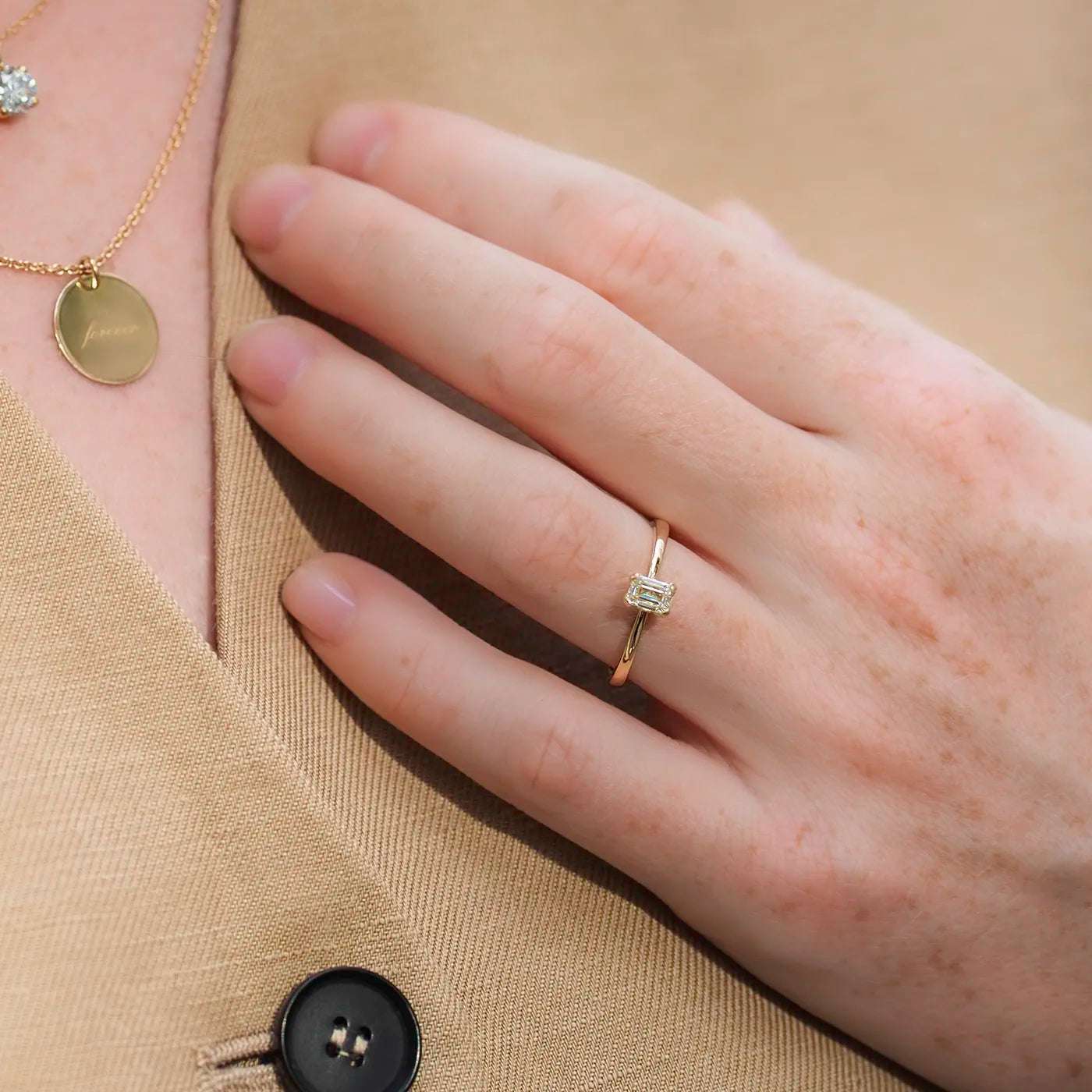 Ring Petite Fleur Solitär aus 750er Gelbgold mit Diamant im Smaragdschliff 0,50 ct an Modellhand am Körper