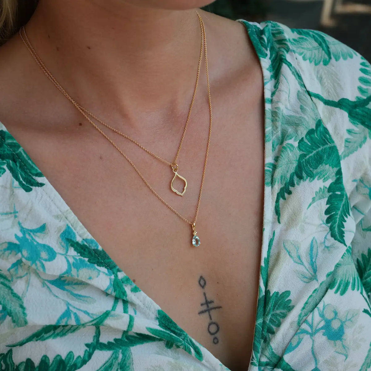Kette Leaf klein und Kette Blossom hellblauer Topas aus 925er Sterlingsilber vergoldet - am Hals getragen, Schrägansicht